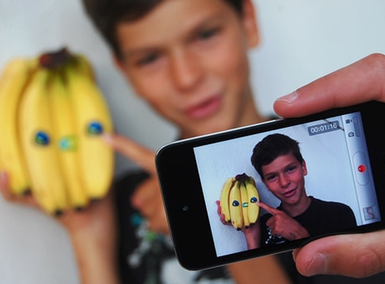 Bild: Jugendlicher mit Handy und Öko-Bananen